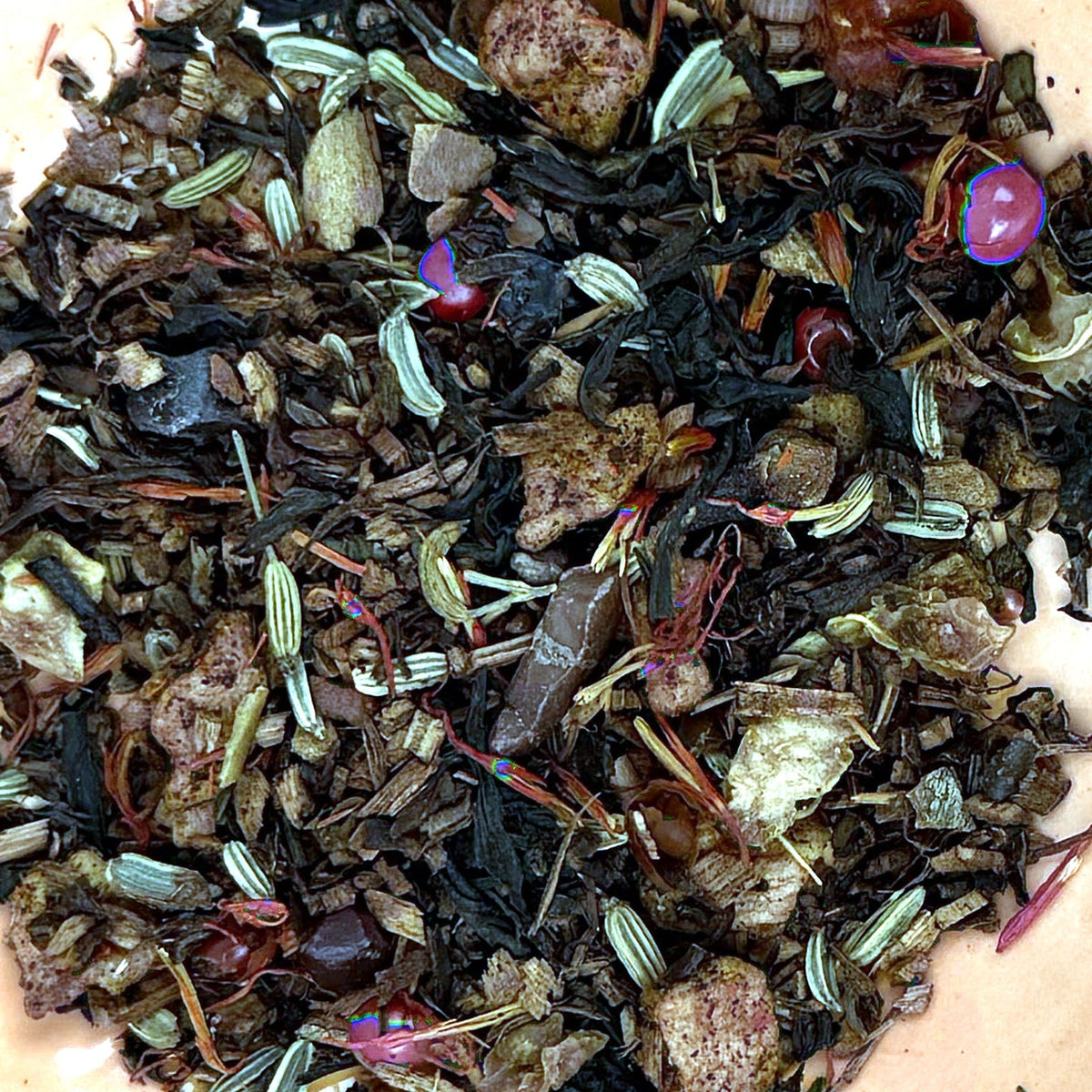 Close-up of The Púca's Bonfire loose tea leaves with red peppercorns